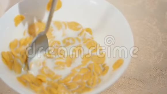 勺子把雪花和牛奶混合在碗里慢慢地搅拌视频的预览图
