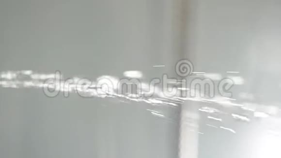 白色背景浴室淋浴喷头上的水滴在白色背景上溅水落水者视频的预览图