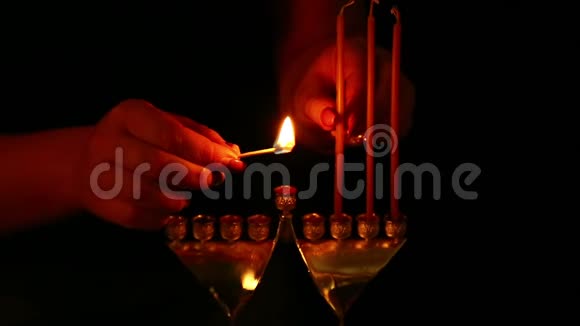 一个女人用自己的手在烛台上放蜡烛静态摄像机视频的预览图