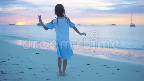 日落时在海滩上跳舞的小女孩的小寿星视频的预览图