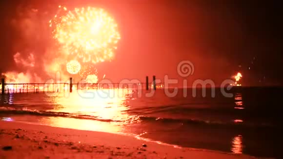 明亮的金色焰火在海面上的夜空中爆炸视频的预览图