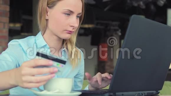 美丽的女人用她的信用卡和笔记本电脑在网上购物视频的预览图