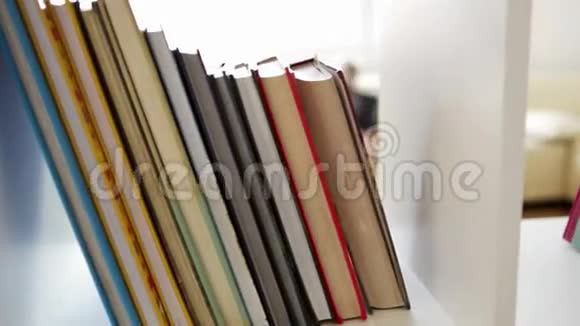 一架照相机窥视着从书架后面看书的小男孩视频的预览图