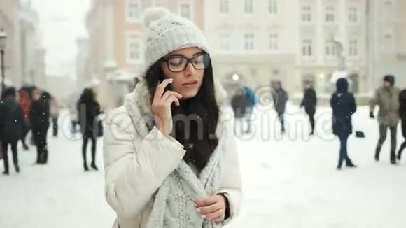 快乐寒假圣诞节饮料和人的概念快乐女孩在电话里交谈城市下雪冬天视频的预览图