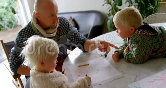 父亲帮助孩子在家画画视频的预览图