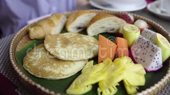 蜂蜜滴下一个煎饼早上早餐带热带水果牛角面包视频的预览图