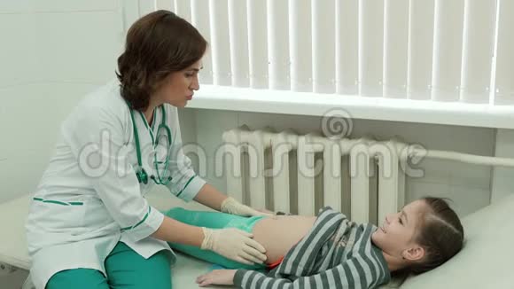 女医生检查一个小女孩的腹部视频的预览图