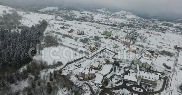 冬天的山坡上撒满了雪下雪的村庄空中景观视频的预览图