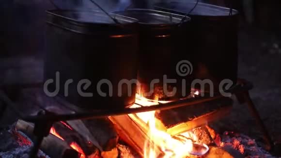 人们用篝火在金属桶里加热水视频的预览图