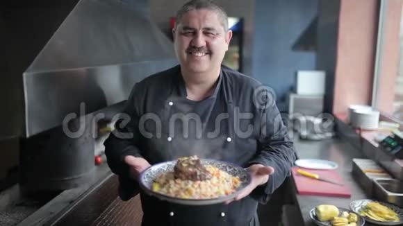 厨师在皮拉夫和羊肉的相机盘子上展示视频的预览图