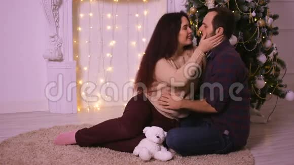 圣诞快乐的情侣坐在壁炉前相爱享受他生命中快乐的时刻视频的预览图