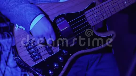 低音吉他关闭在摇滚音乐会上弹吉他的人4kUHD视频视频的预览图