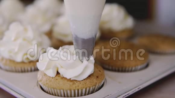 使用烹饪袋糖果制作纸杯蛋糕把奶油放到美味的松饼上视频的预览图