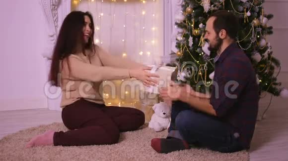 漂亮的年轻女人在圣诞节给她男朋友一份漂亮的礼物视频的预览图