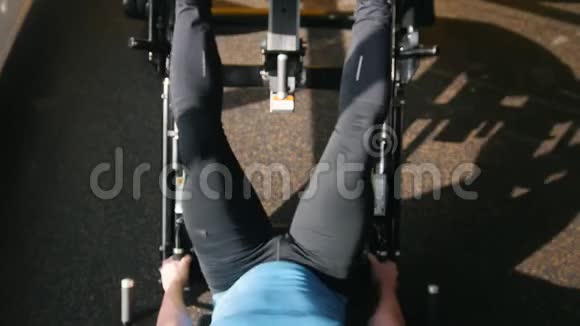 健身俱乐部肌肉男在腿部按压机上锻炼关闭视频的预览图