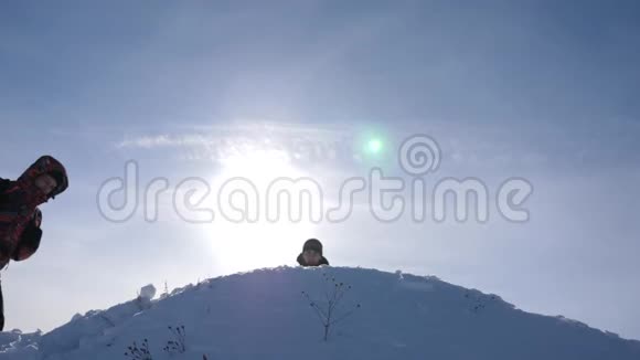 旅行者在成功的基础上相遇游客们来到雪山顶上在黄色的背景下为胜利而欢呼视频的预览图