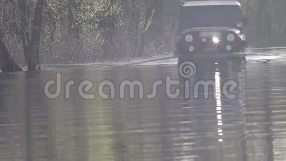 汽车迫使河水流向森林大雨过后乡村公路被淹视频的预览图