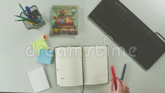 一个女人在日记中写下一个词的俯视图视频的预览图