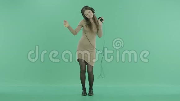 一个女孩用耳机和舞蹈听音乐视频的预览图
