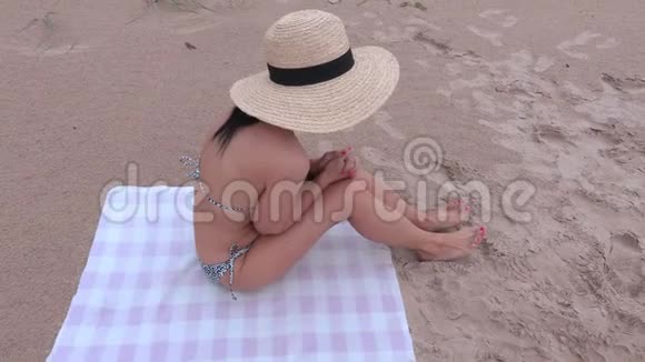 穿比基尼和草帽的女人在海滩上视频的预览图