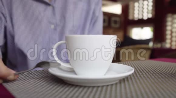 女人的特写镜头在咖啡馆里搅动热饮咖啡或茶视频的预览图