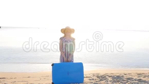 年轻快乐的女人带着一个大箱子在海滩上视频的预览图