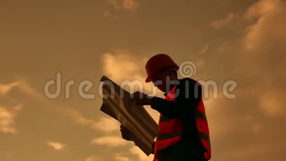 工人剪影工人建筑工人与红色头盔和牛仔裤衬衫附近的工业墙剪影工人视频的预览图