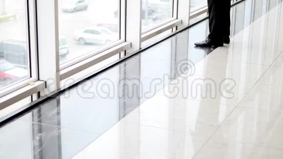 一个人站在最高的位置凝视着机场候机楼的窗户视频的预览图