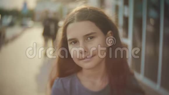 城市中一个小女孩的肖像人群散步人们慢动作视频女孩青少年的阳光肖像城市视频的预览图