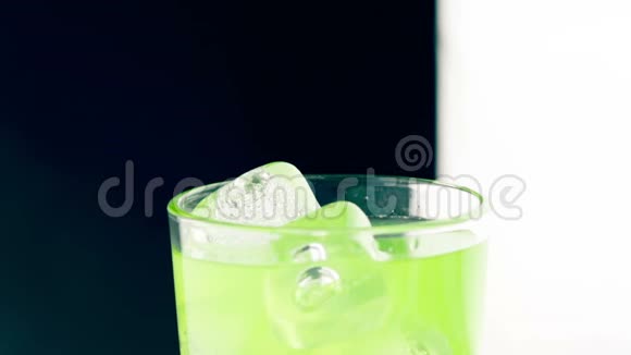 男人的特写镜头将黄色柠檬挤在酒精鸡尾酒杯中加入冰块享受俱乐部的乐趣视频的预览图