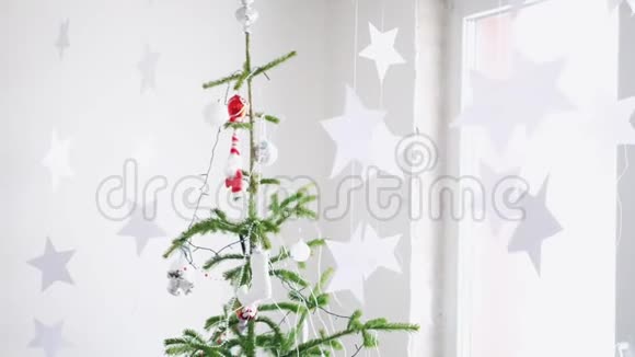 纸上的星星挂在窗户旁边的冷杉树旁边作为圣诞节内部的背景慢动作圣诞节视频的预览图