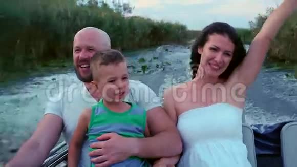 幸福的一家人很快就乘着快艇沿着河走了幸福的母亲父亲和儿子享受着假期坐着船视频的预览图