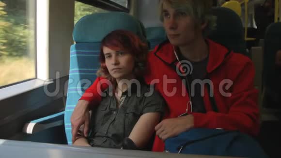 年轻漂亮快乐的时髦夫妇坐在火车旁看着窗户暑假视频的预览图