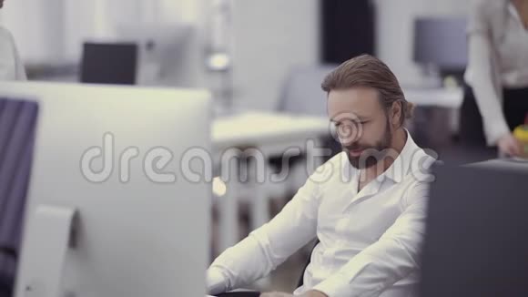 英俊的商人在办公室的电脑上工作视频的预览图