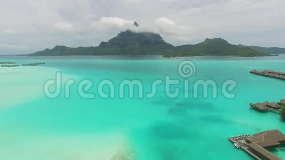 在水晶般清澈的绿松石海水中在波拉波拉法属波利尼西亚热带绿色岛屿上的迷人空中4k景观视频的预览图