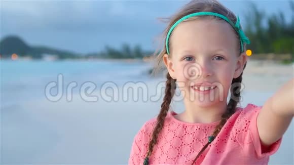 可爱的小女孩在热带白色海滩自拍流动人口视频的预览图