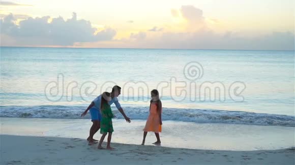 父亲和孩子们在日落时享受海滩夏日热带度假流动人口视频的预览图