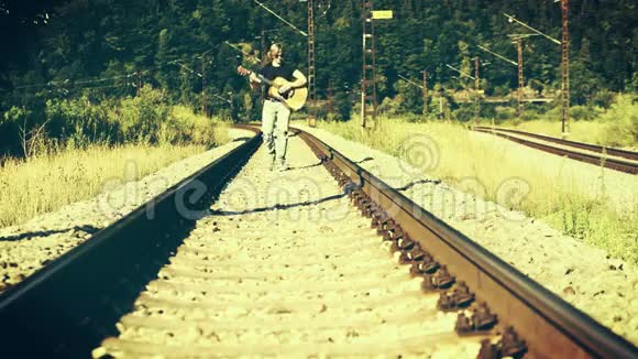 一个左撇子吉他手沿着铁路走弹视频的预览图