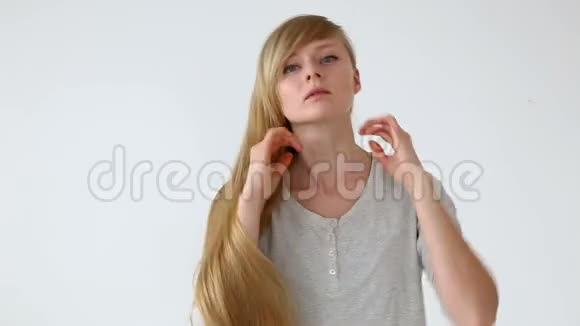 美丽的欧洲长发女孩金发在白色背景下形成不同的发型视频的预览图