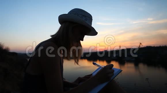 在日落时分在河边有一个笔记本的创意个性视频的预览图
