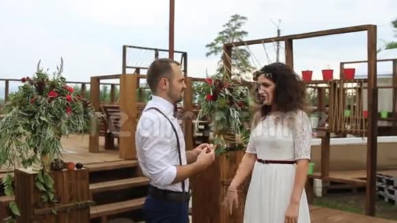 迷人的是新郎在新娘的手指上戴着结婚戒指概念婚礼乡村化视频的预览图