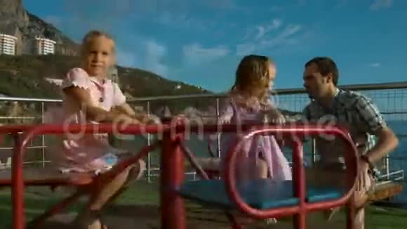 爸爸看着他的小女儿如何骑在旋转木马上视频的预览图