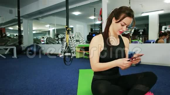 体育女孩微笑着在健身房拍照体育女孩自拍网络交流视频的预览图