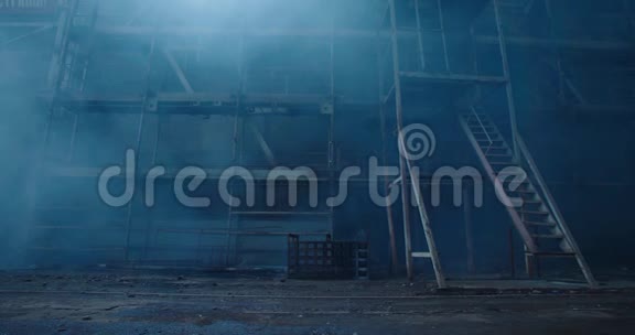 旧的织物制造大楼在烟雾中黑暗空间的大气层废弃的工厂大厅窗户上有破碎的玻璃世界末日视频的预览图