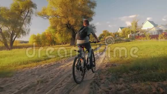 阳光明媚的一天十几岁的男孩在城市公园骑自行车健康的生活方式观念视频的预览图