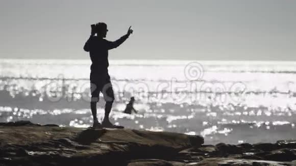海边的男人正在拍摄一幅奇妙的风景视频的预览图
