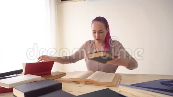那个头发粉红的女孩正坐在桌子旁看书视频的预览图