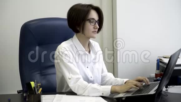 年轻漂亮的女商人穿着白色衬衫留着一头乌黑的短发在办公室工作累了青年办公室视频的预览图