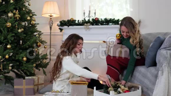 可爱的女孩看圣诞装饰品圣诞树的装饰品圣诞花环玩具球女孩都是视频的预览图