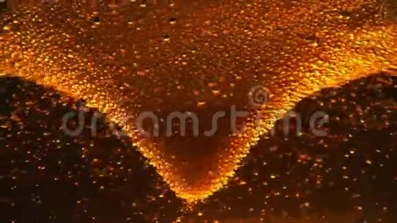 啤酒泡在漩涡中高速漂浮在黑色背景下的宏观玻璃中视频的预览图